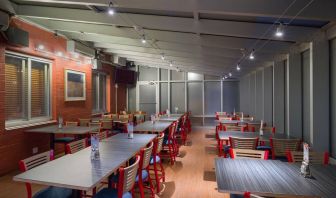 The hotel’s breakfast area, which has a hard floor and tables for four or more diners.