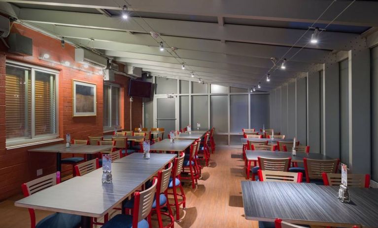 The hotel’s breakfast area, which has a hard floor and tables for four or more diners.