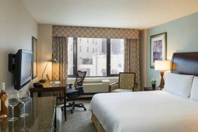 Guest room in the Hilton Garden Inn Tribeca, furnished with large bed, desk and chair for working, and TV.