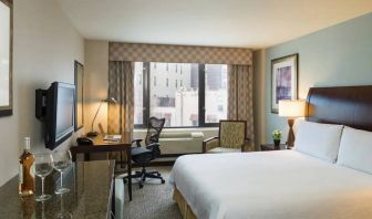 Guest room in the Hilton Garden Inn Tribeca, furnished with large bed, desk and chair for working, and TV.