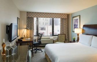 Guest room in the Hilton Garden Inn Tribeca, furnished with large bed, desk and chair for working, and TV.