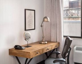 An in-room work station at the Hilton Garden Inn Tribeca, with lamp, chair, and desk.