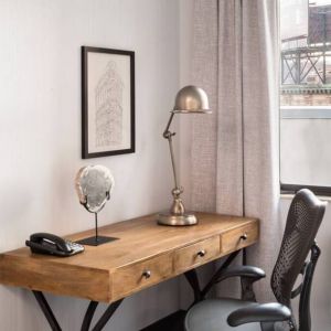 An in-room work station at the Hilton Garden Inn Tribeca, with lamp, chair, and desk.