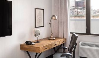 An in-room work station at the Hilton Garden Inn Tribeca, with lamp, chair, and desk.