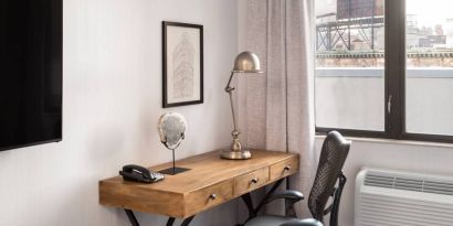 An in-room work station at the Hilton Garden Inn Tribeca, with lamp, chair, and desk.