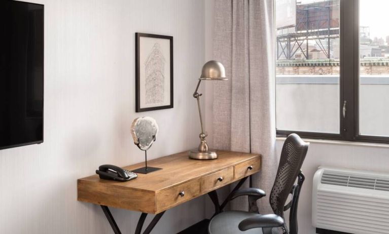 An in-room work station at the Hilton Garden Inn Tribeca, with lamp, chair, and desk.