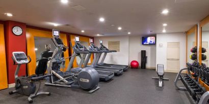 The hotel fitness center, which is equipped with weights, an exercise bench, and multiple machines.