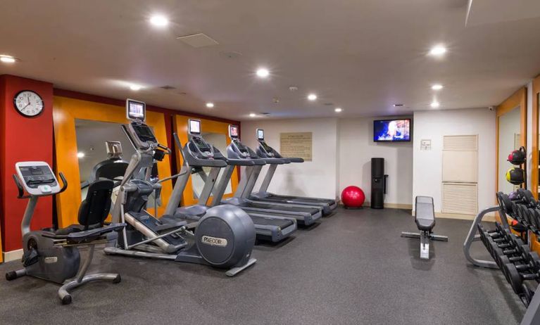 The hotel fitness center, which is equipped with weights, an exercise bench, and multiple machines.