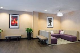 Hampton Inn Times Square South’s lobby lounge, with art on the walls and comfortable sofa seating.