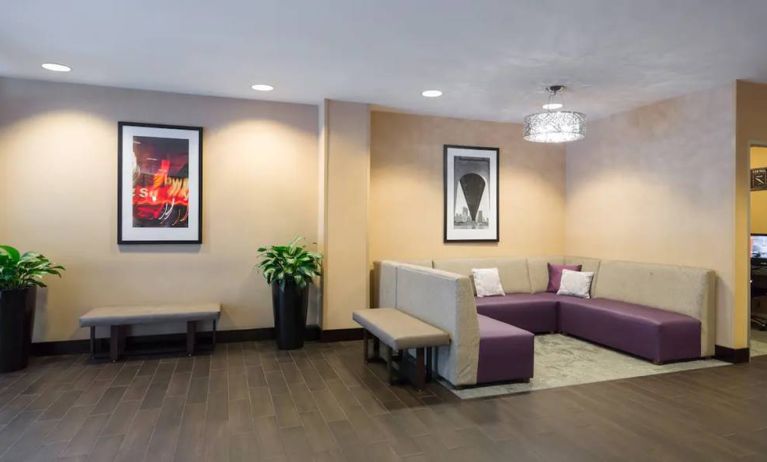 Hampton Inn Times Square South’s lobby lounge, with art on the walls and comfortable sofa seating.