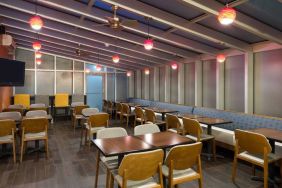 The hotel’s breakfast area, with hard floor and tables for two or four diners.