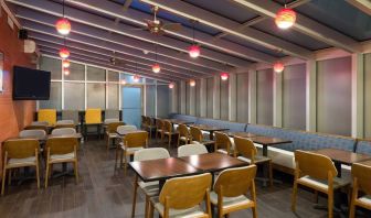 The hotel’s breakfast area, with hard floor and tables for two or four diners.