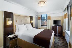 A guest room in the New Yorker Hotel, A Wyndham Hotel with double bed and window.