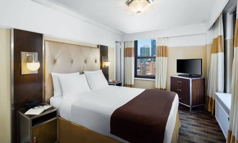 A guest room in the New Yorker Hotel, A Wyndham Hotel with double bed and window.