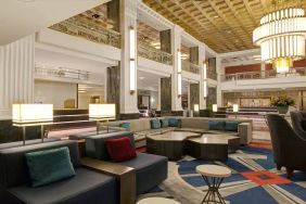 Lounge in the lobby of the New Yorker Hotel, A Wyndham Hotel, with stylish and comfortable sofa seating.