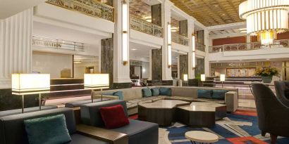 Lounge in the lobby of the New Yorker Hotel, A Wyndham Hotel, with stylish and comfortable sofa seating.