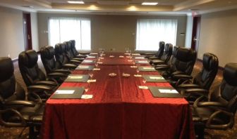 Meeting room with a dozen leather chairs arranged around a long table.