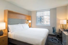 One of Holiday Inn Express Wall Street’s guest rooms, complete with double bed, window, and workspace chair and desk.