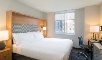 One of Holiday Inn Express Wall Street’s guest rooms, complete with double bed, window, and workspace chair and desk.