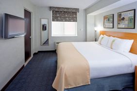 Double bed guest room in the Holiday Inn Express Wall Street, with window, TV, and mirror.