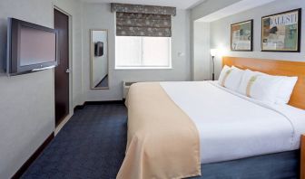 Double bed guest room in the Holiday Inn Express Wall Street, with window, TV, and mirror.