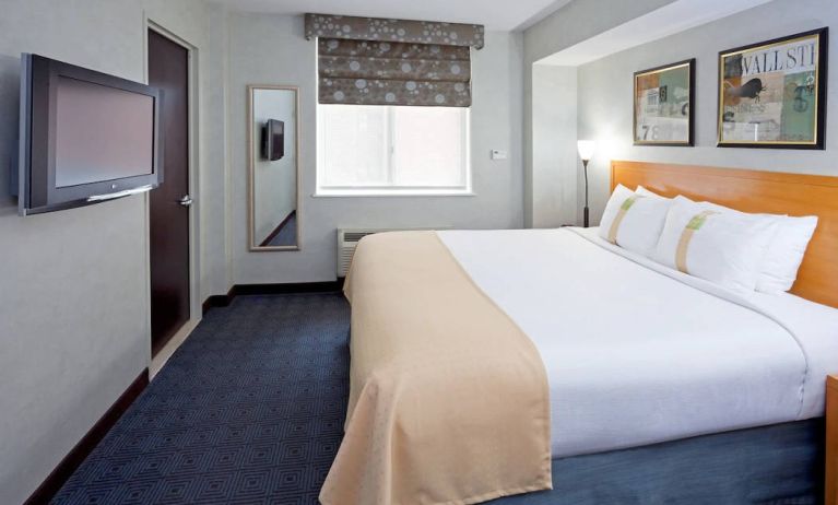 Double bed guest room in the Holiday Inn Express Wall Street, with window, TV, and mirror.