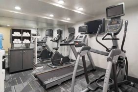 Various exercise machines, towels, and TV in the hotel’s fitness center.