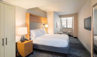 Guest room in the Holiday Inn Express Wall Street, with large television, chairs, and window.