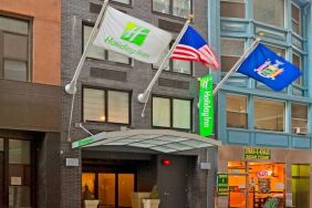 Exterior shot of the Holiday Inn Express Wall Street and its trio of fluttering flags.