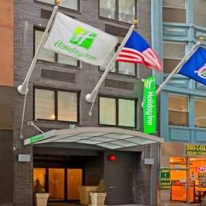 Exterior shot of the Holiday Inn Express Wall Street and its trio of fluttering flags.