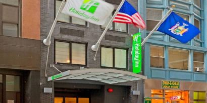 Exterior shot of the Holiday Inn Express Wall Street and its trio of fluttering flags.