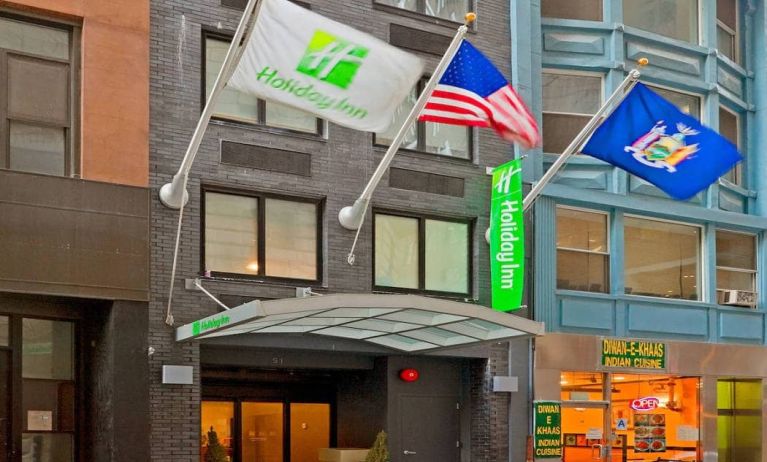 Exterior shot of the Holiday Inn Express Wall Street and its trio of fluttering flags.