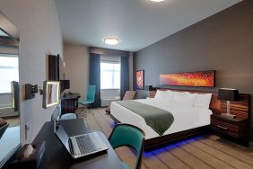 Comfortable king room with work desk and TV at Hotel Clique Calgary Airport.