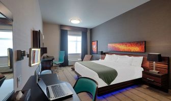 Comfortable king room with work desk and TV at Hotel Clique Calgary Airport.