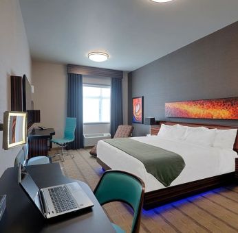 Comfortable king room with work desk and TV at Hotel Clique Calgary Airport.