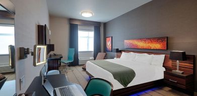 Comfortable king room with work desk and TV at Hotel Clique Calgary Airport.