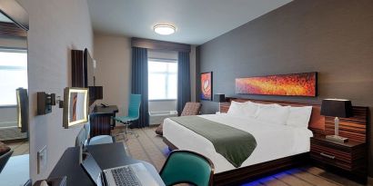 Comfortable king room with work desk and TV at Hotel Clique Calgary Airport.