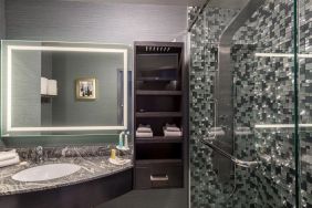 Spacious guest bathroom with shower at Hotel Clique Calgary Airport.