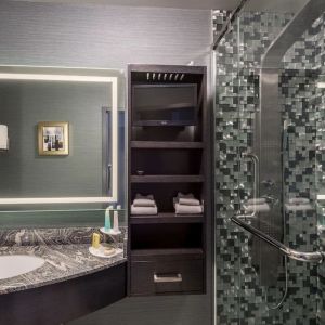 Spacious guest bathroom with shower at Hotel Clique Calgary Airport.