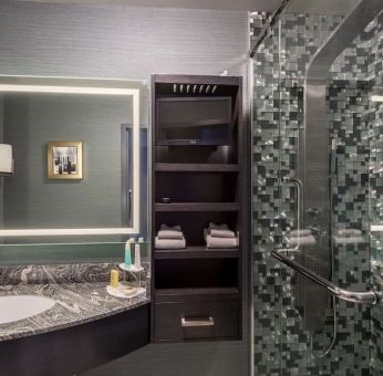 Spacious guest bathroom with shower at Hotel Clique Calgary Airport.