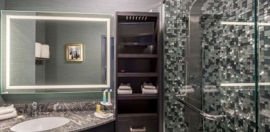 Spacious guest bathroom with shower at Hotel Clique Calgary Airport.