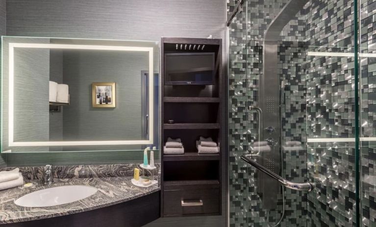 Spacious guest bathroom with shower at Hotel Clique Calgary Airport.