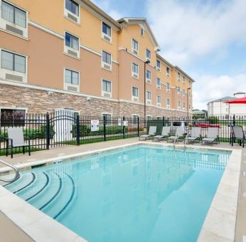 Stunning outdoor pool with seating area at Hawthorn Suites By Wyndham Longview.