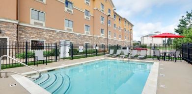 Stunning outdoor pool with seating area at Hawthorn Suites By Wyndham Longview.