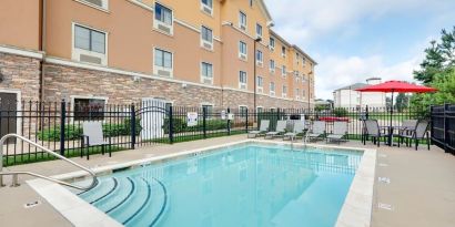 Stunning outdoor pool with seating area at Hawthorn Suites By Wyndham Longview.