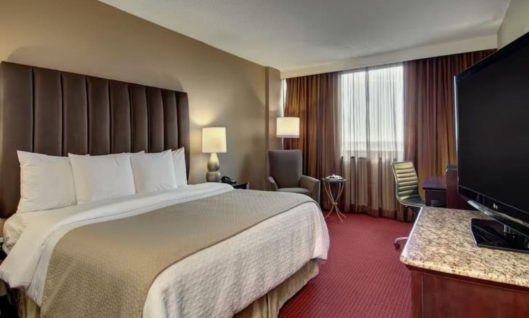 Delux king room with TV and work space at Embassy Suites By Hilton West Palm Beach Central.