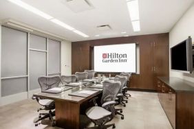 A hotel meeting room, with eight chairs arranged around a long table.