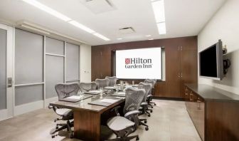 A hotel meeting room, with eight chairs arranged around a long table.