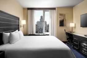 Delux king room with TV and business desk at Hilton New York Fashion District.