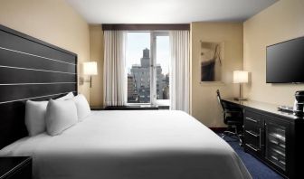 Delux king room with TV and business desk at Hilton New York Fashion District.